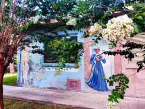 A mural in historic downtown Brooksville showing a standing family and a woman strolling in Victorian-era attire.