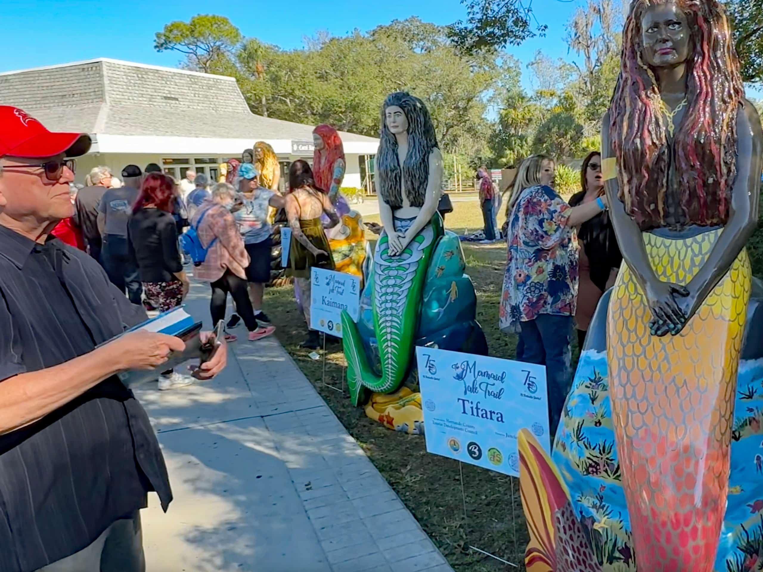 A man views one of the mermaid statues during the unveiling of The Mermaid Tale Trail