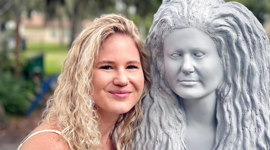 Mermaid Kristy, a performer at Weeki Wachee Springs State Park, smiles while posing next to an unpainted statue, which was molded after her face.