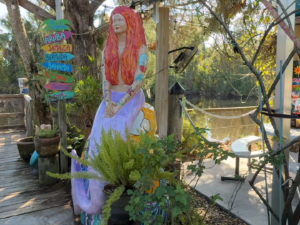 A painted Mermaid Statue named 'The Rebel' in the lush tropical garden at the Silver Dolphin Restaurant